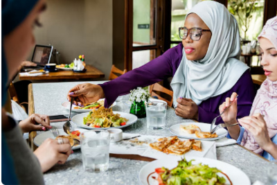 Muslim women sitting together and eating Halal food.