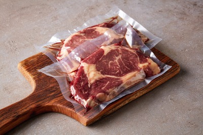 Sealed meat packages on wooden stewer.