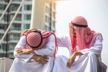 An Arab man consoling another Muslim man.