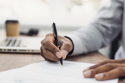 A man signing Halal cert contract.