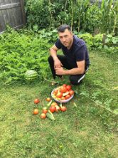 ISA employee Arben with garden vegetables