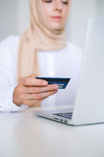 A Muslim woman is online shopping with her credit card.