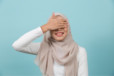 Young Muslim woman covering her eyes.