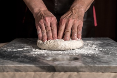 Man preparing pizza dough.