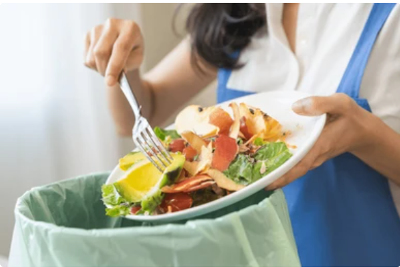 A woman throwing food waste into the garbage.