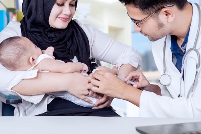 Muslim doctor is giving vaccine to a Muslim baby.